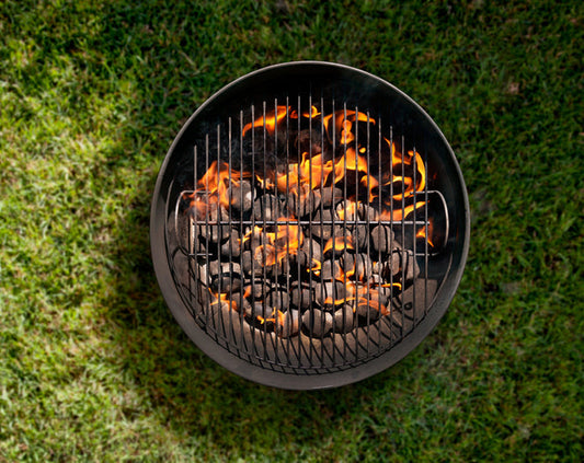 Top-down view of lit charcoal inside a UDS kit, ready for smoking.